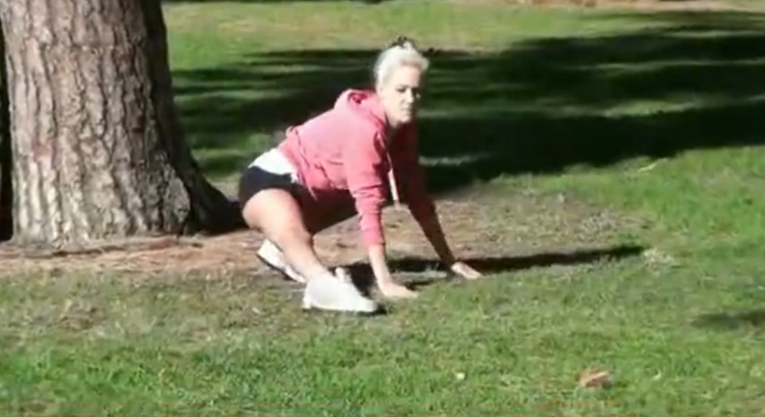 Подглядывание девушка занимается гимнастикой в парке