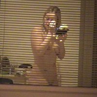 Голая девушка в окне с открытыми жалюзями